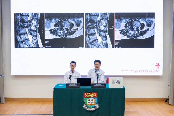 由鍾培言教授（右）及關日康醫生領導的港大醫學院科研團隊，介紹首次在本港使用輔助機械臂進行脊椎手術的情況。